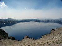 Forest fire smoke creeping over the lake